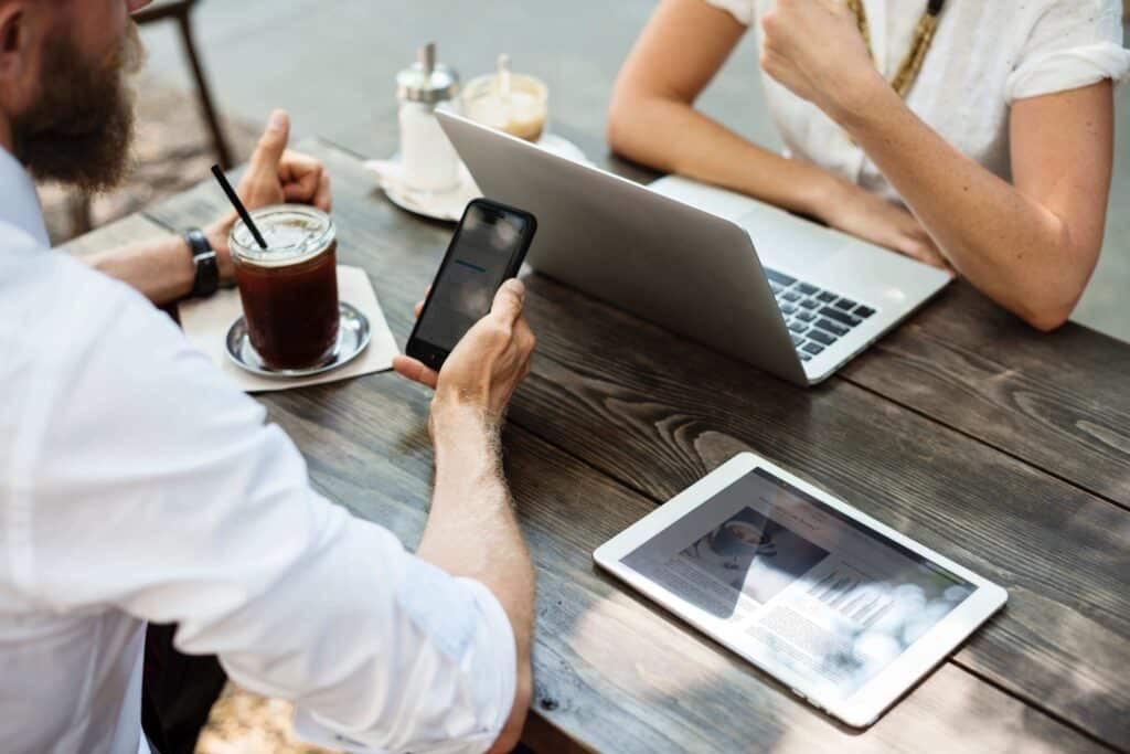 People using laptop and cell phone in meeting