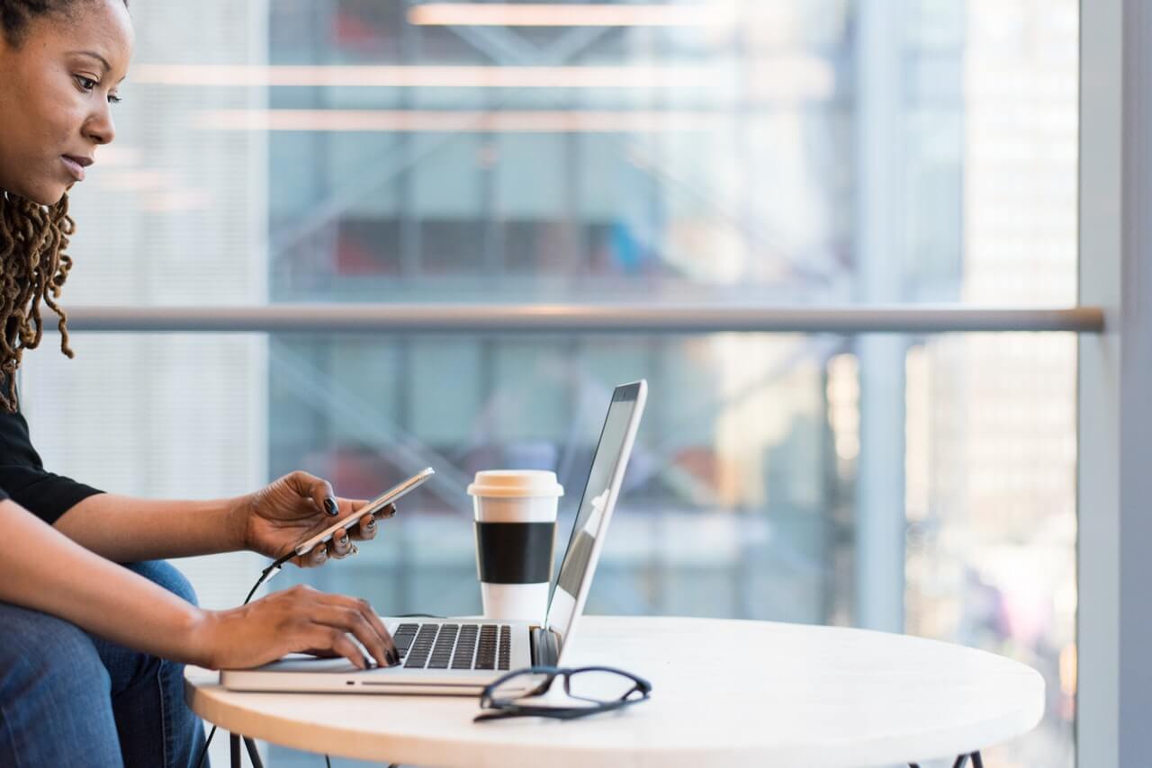 Woman working on laptop in front of window