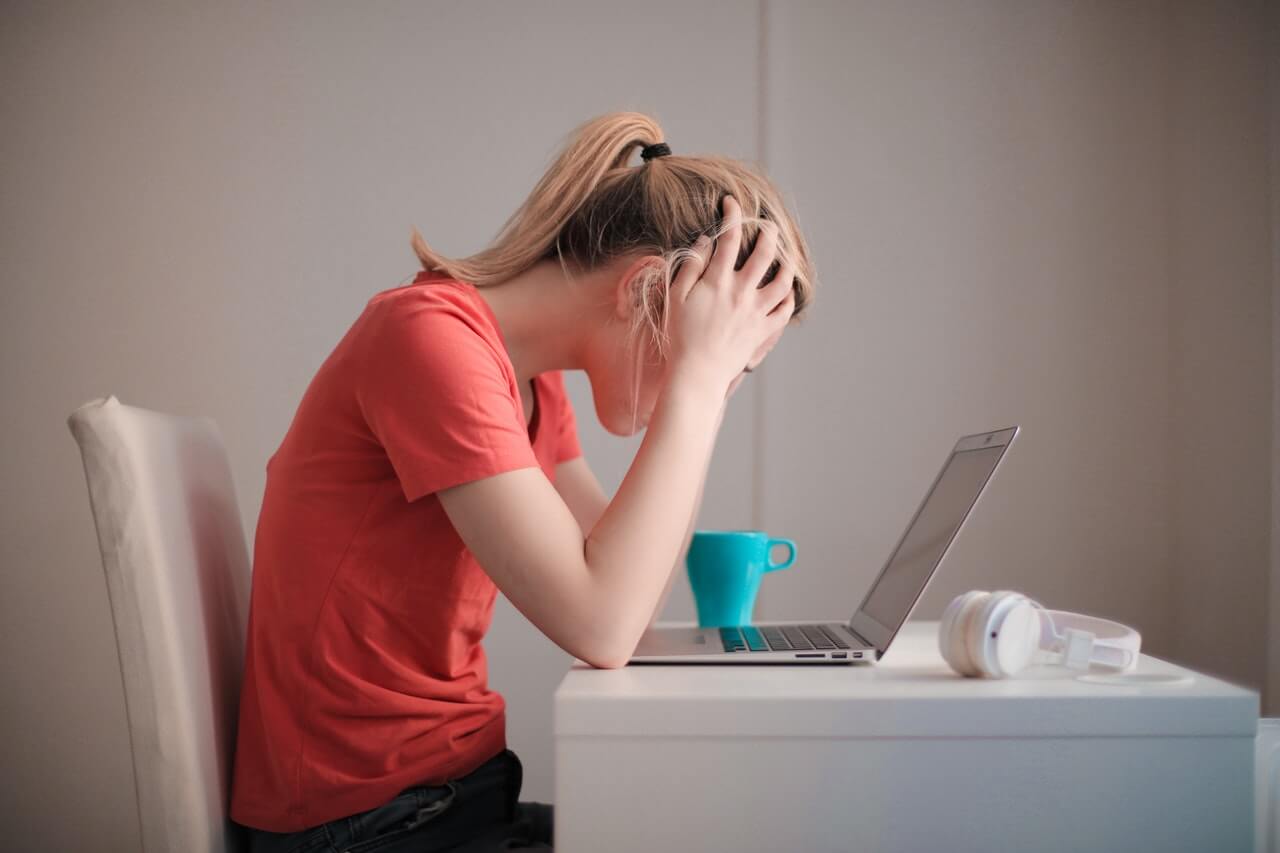 Stressed woman with head in hands