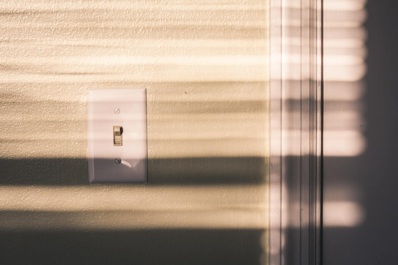 Light switch on wall in sunlight