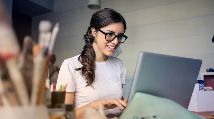 A lady writing an essay on a laptop