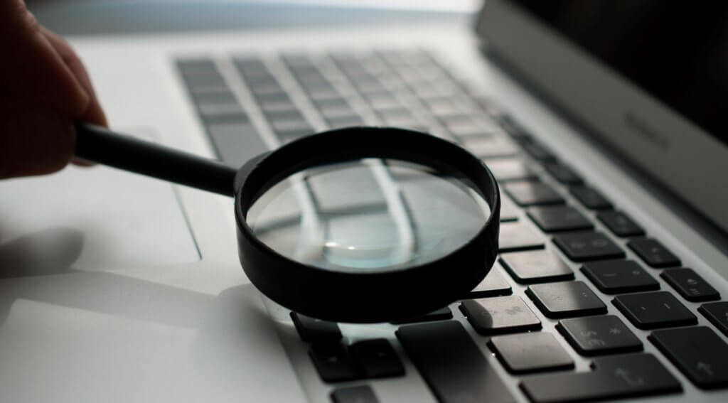 Magnifying glass over a laptop keyboard